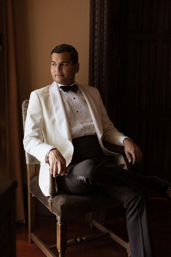 Groom portraits in Peru, sitting in a chair looking out into the distance