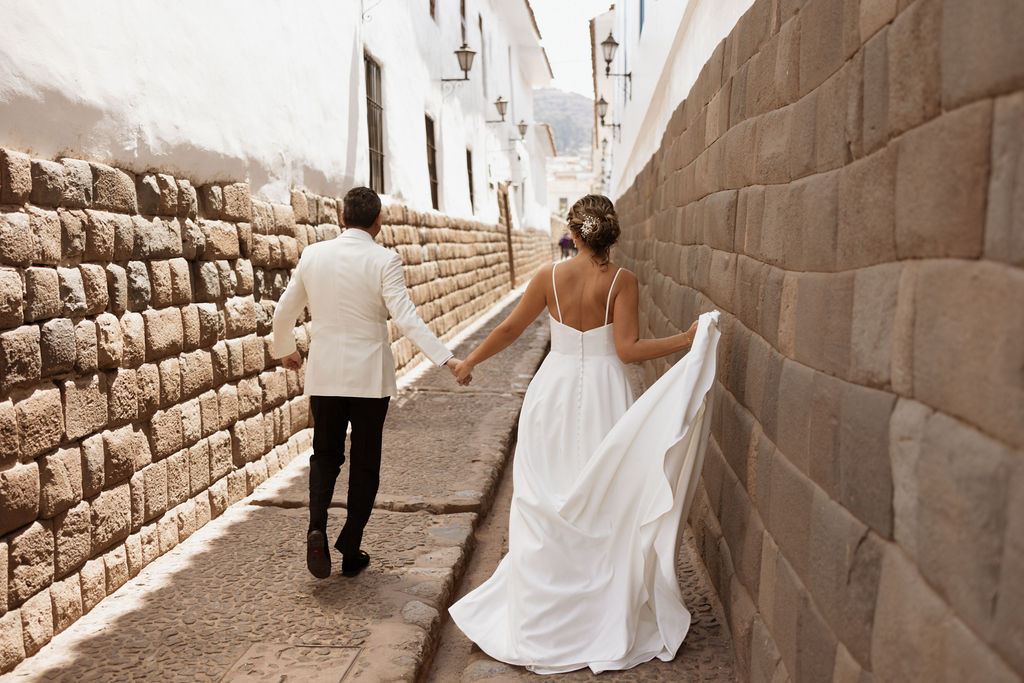 Bride and groom holding hands walking in Peru