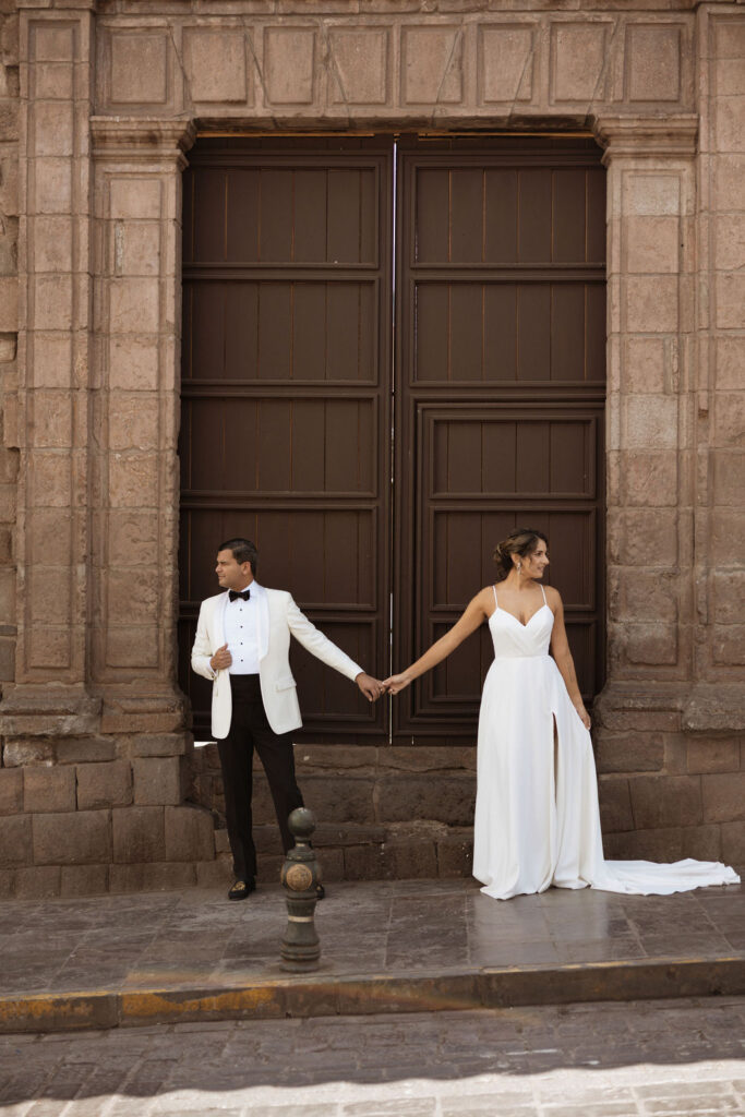 Bride and groom holding hands for portraits in Peru
