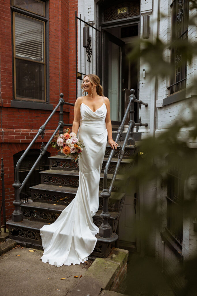 bridal portrait of bride standing on the stairs outside with her wedding dress and bridal bouquet 
