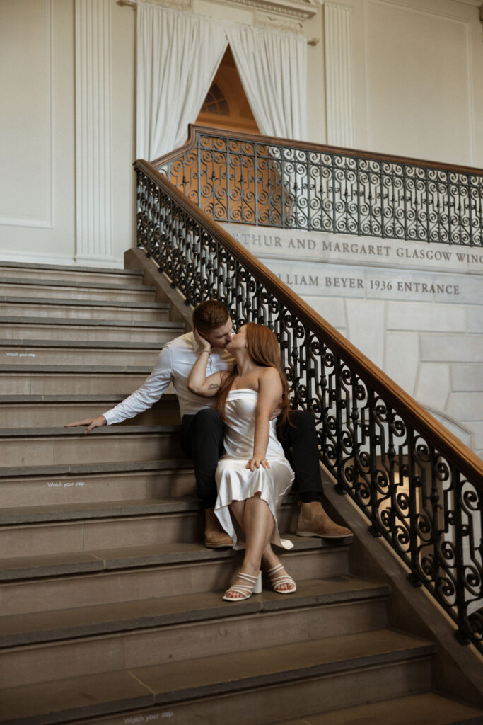 engagement session of couple sitting on the stairs at the VMFA