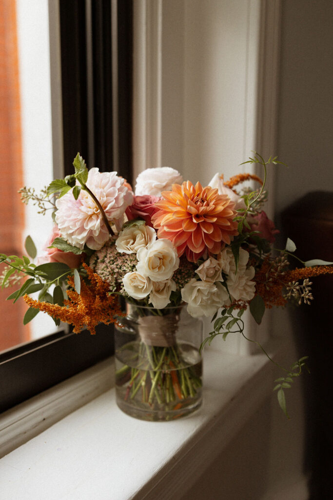 detail wedding photo of a bridal bouquet sitting on the ledge of a window