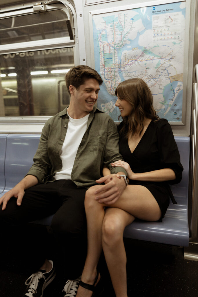 engagement session in new york city of couple sitting on the subway together smiling 