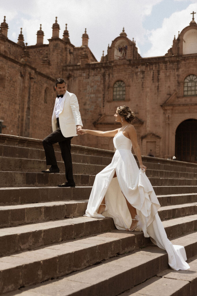 bride and groom walking up the stairs together holding hands at their destination wedding in peru