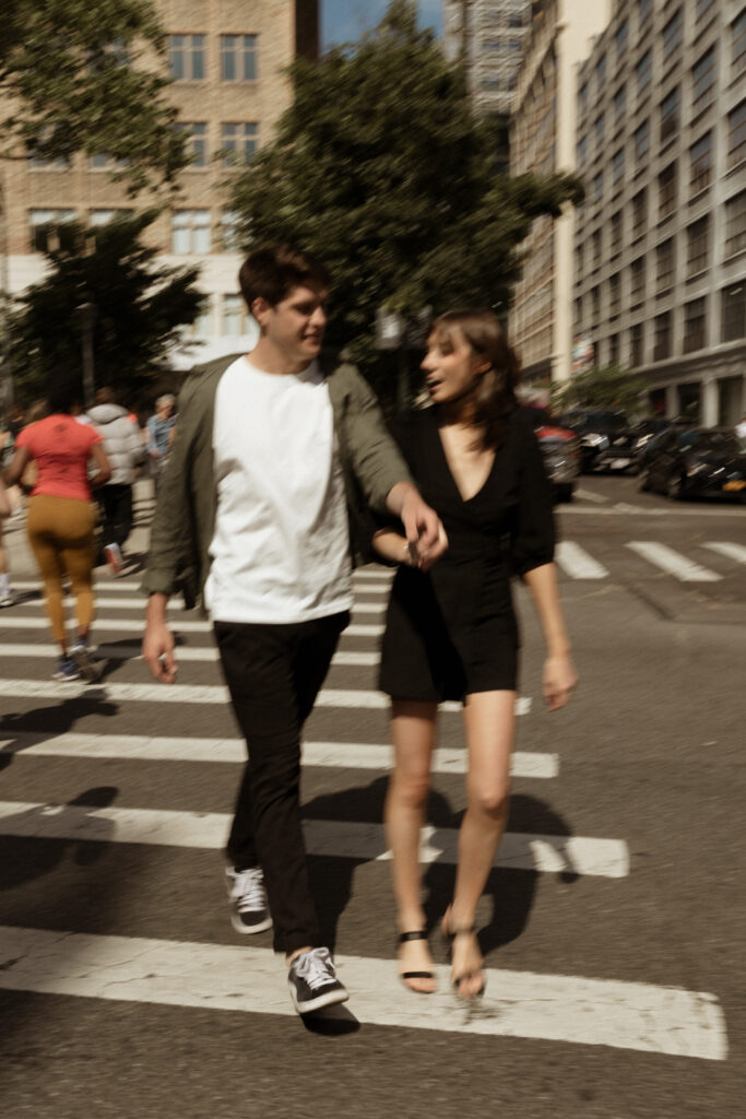 engagement session in new york with couple holding hands crossing the street together