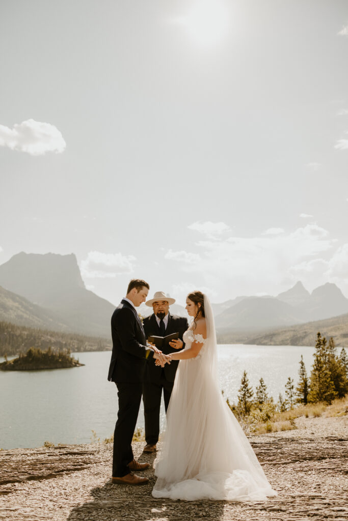elopement at Glacier National Park of bride and groom holding hands at their ceremony