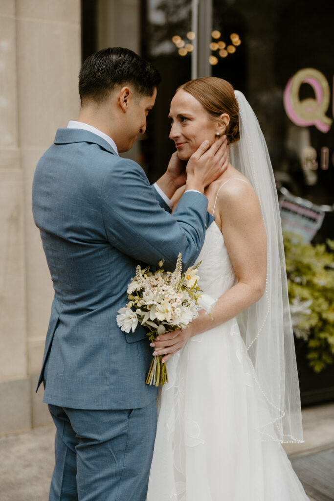 city wedding photos of groom holding brides face while they look at each other